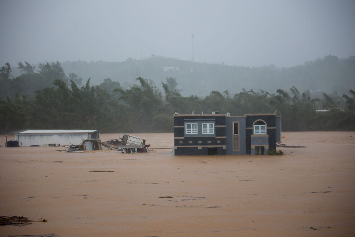 Tres personas dentro de una casa aguardan a ser rescatadas de las inundaciones provocadas por el huracán Fiona, en Cayey. Foto: Stephanie Rojas | AP