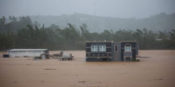 Tres personas dentro de una casa aguardan a ser rescatadas de las inundaciones provocadas por el huracán Fiona, en Cayey. Foto: Stephanie Rojas | AP