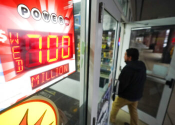 Un cliente entra en una licorería con un cartel de Poweball en Baltimore. Foto: Julio Cortez / AP