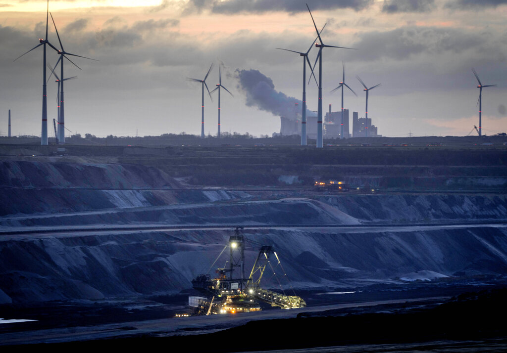 Personal realiza labores en la mina de carbón Garzweiler con un parque eólico como fondo, en Luetzerath, Alemania, el miércoles 2 de noviembre de 2022. Foto: AP/Michael Probst