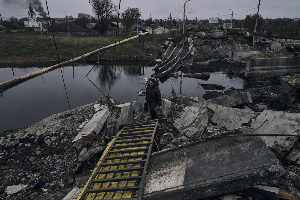 Una mujer camina por un puente destrozado en Bakhmut, Ucrania, el 11 de noviembre de 2022. (Foto / LIBKOS / AP)