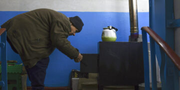 Un habitante junto a una estufa en Lyman, Donetsk, Ucrania, el 20 de noviembre de 2022. (Foto AP/Andriy Andriyenko)