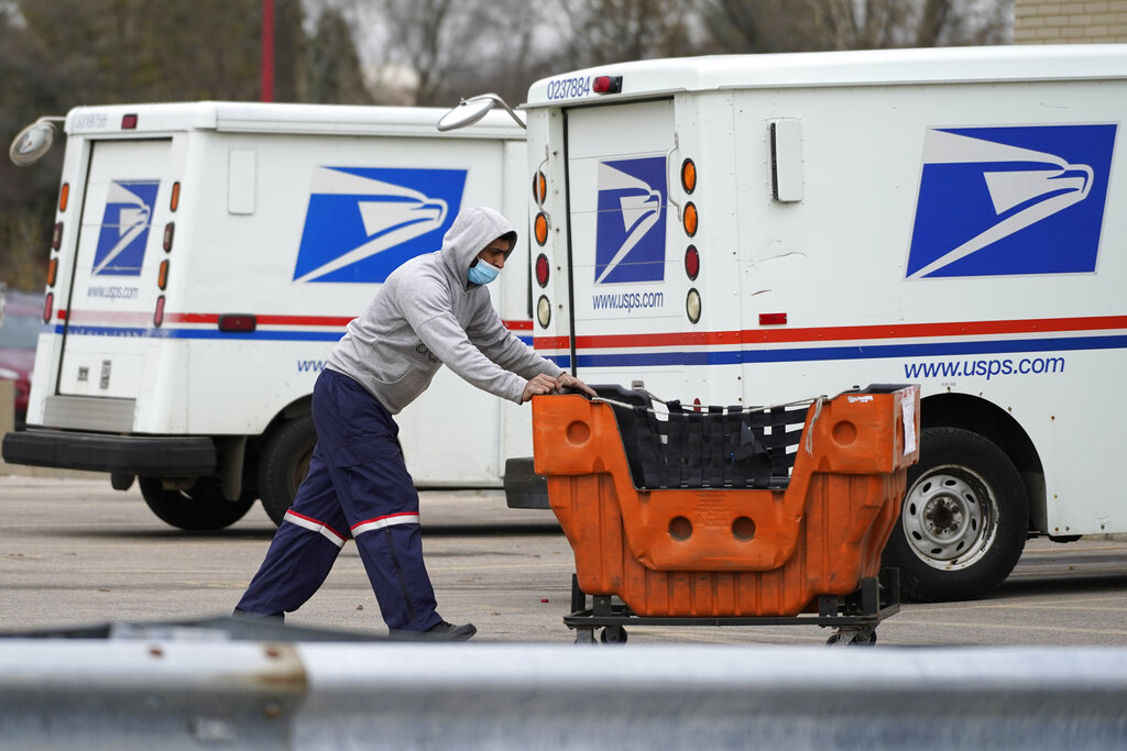 Una persona con unos paquetes frente a una oficina postal en Wheeling, Illinois. (Foto AP/Nam Y. Huh/Archivo)