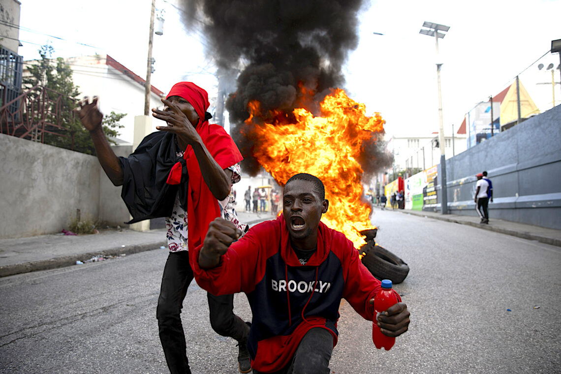 Manifestantes gritan consignas contra el gobierno frente a una barricada de neumáticos en llamas durante una protesta en Puerto Príncipe, Haití. (Foto: Odelyn Joseph | AP, archivo)
