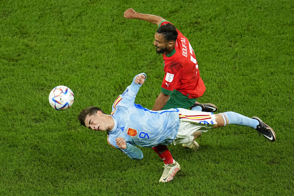 El marroquí Sofiane Boufal pugna un balón con el español Gavi durante el partido de octavos de final del Mundial, el martes 6 de diciembre de 2022, en Rayán, Qatar. (AP Foto/Abbie Parr)