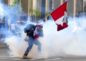 Un simpatizante del destituido presidente Pedro Castillo devuelve un contenedor de gas lacrimógeno en dirección a la policía. (Foto: Martin Mejia | AP)