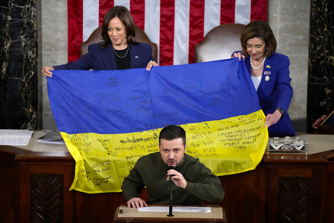 La vicepresidenta Kamala Harris, a la izquierda, y la presidenta de la Cámara de Representantes Nancy Pelosi, sostienen la bandera ucraniana firmada por soldados en el frente de batalla en Bakhmut, que el presidente de Ucrania Volodymyr Zelenskyy obsequió a los legisladores, durante un discurso de Zelenskyy en el Capitolio. (Foto: Jacquelyn Martin | AP)