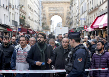Transeúntes se agolpan detrás de la cinta que rodea la escena donde se produjo un tiroteo en el centro de París. (Foto: Lewis Joly | AP)