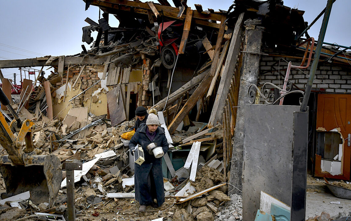 Personas cargan sus pertenencias al dejar sus casas destrozadas en el ataque con cohete ruso en Zaporiyia, Ucrania. (Foto: Andriy Andriyenko | AP)