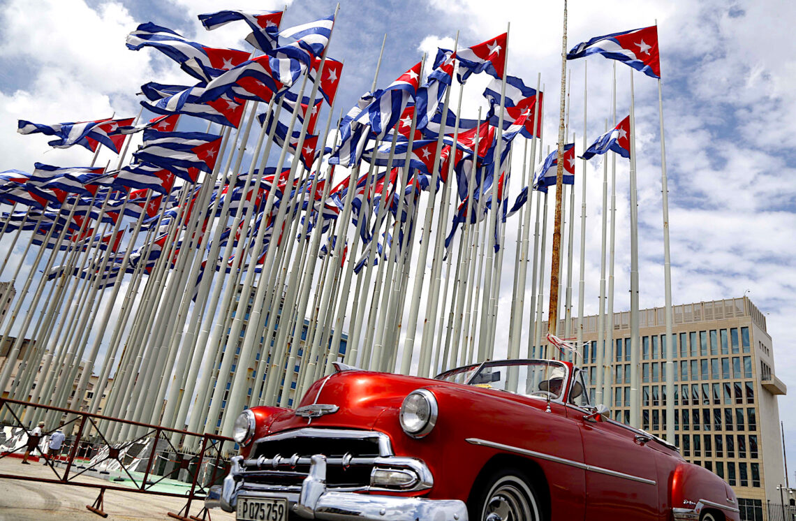 En esta imagen de archivo, un auto descapotable clásico estadounidense pasa junto a la embajada de Estados Unidos mientras las banderas cubanas ondean en la Tribuna Antiimperialista, en el Malecón, en La Habana, Cuba. (Foto: Desmond Boylan | AP, archivo)