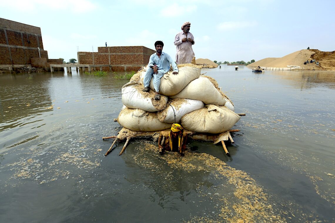 Víctimas de inundaciones provocadas por las lluvias monzónicas usan una balsa improvisada con el fin de transportar paja para el ganado, el 5 de septiembre de 2022, en Jaffarabad. (Foto: Fareed Khan | AP)