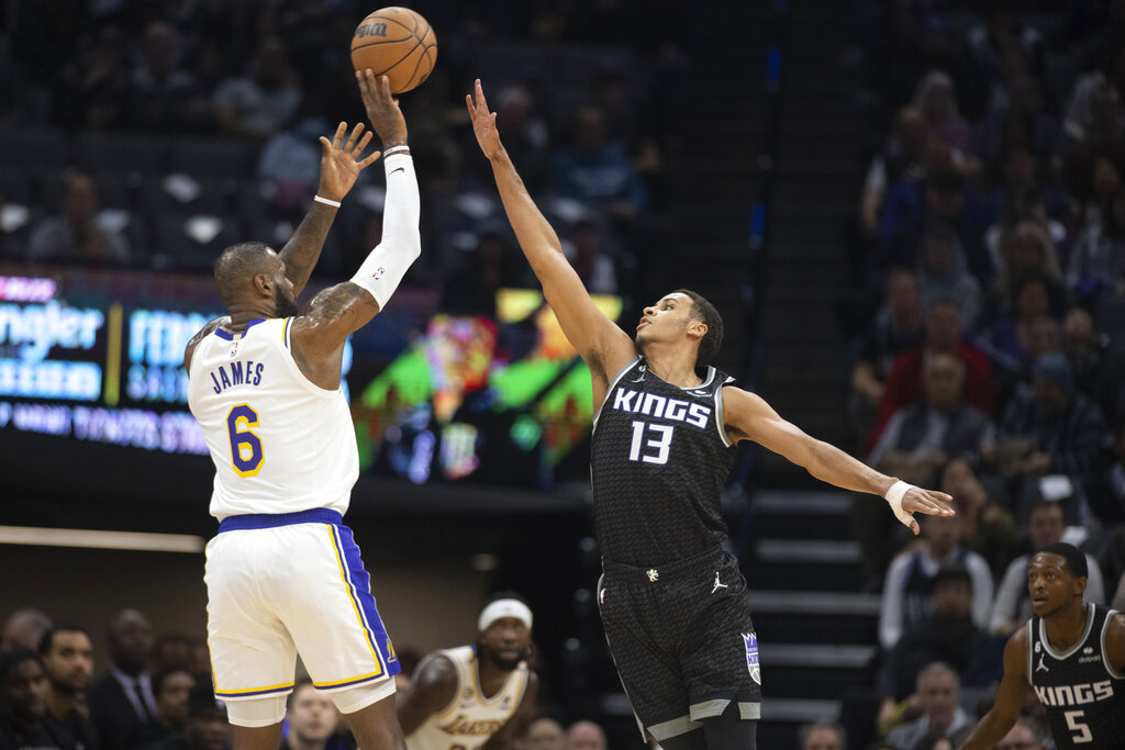 LeBron James, de los Lakers de Los Ángeles, dispara ante la defensiva de Keegan Murray, de los Kings de Sacramento, en el primer cuarto del partido del sábado 7 de enero de 2023, en Sacramento, California. (AP Foto/José Luis Villegas)
