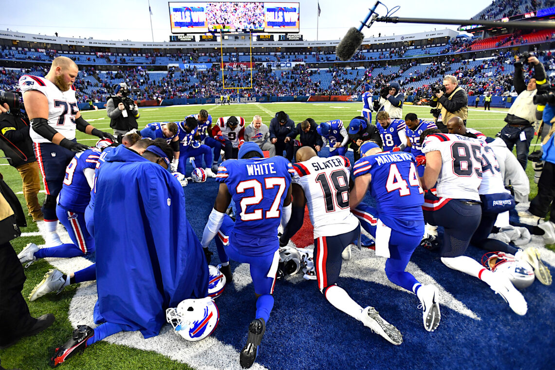 Los jugadores de los Bills de Buffalo y los Patriots de Nueva Inglaterra oran tras su partido en Orchard Park, Nueva York (Foto: Adrian Kraus | AP)