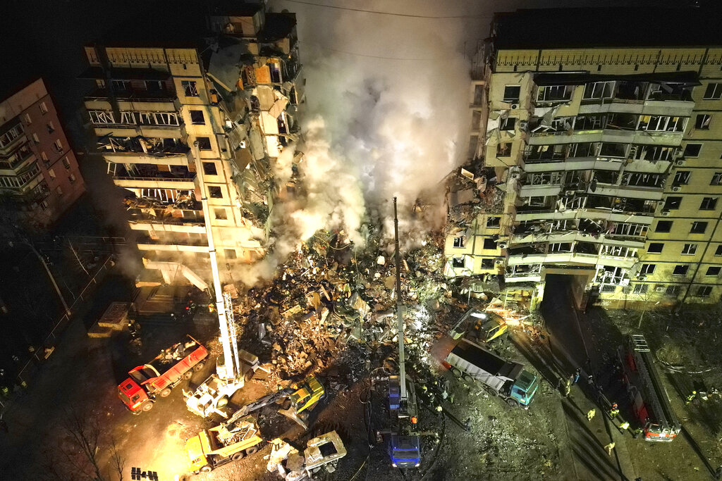 Socorristas buscan a personas atrapadas en los escombros después de que cohete ruso impactó en un edificio de apartamentos en la ciudad de Dnipro, en el sureste de Ucrania, el sábado 14 de enero de 2023. (Foto AP/Evgeniy Maloletka)