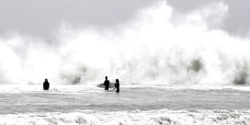 Surfistas aprovechan las olas durante una tormenta en Venice Beach, en Los Ángeles, el sábado 14 de enero de 2023. (Keith Birmingham/The Orange County Register vía AP)