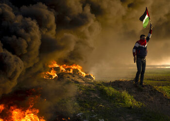 Palestinos queman neumáticos y ondean la bandera nacional durante una protesta contra un operativo militar israelí en Yenín, Cisjordania. (Foto: Fatima Shbair | AP)