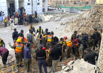 Agentes de seguridad y rescatistas buscan cuerpos en el lugar de un ataque suicida en Peshawar, Pakistán. (Foto: Zubair Khan | AP)