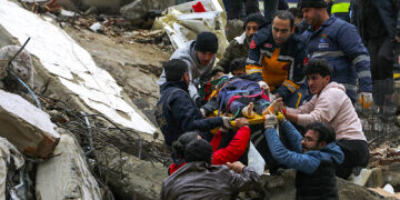Gente y equipos de rescatistas trasladan a una persona en camilla desde un edificio derruido en Adana, Turquía, el lunes 6 de febrero de 2023. (Foto: IHA agency via AP)