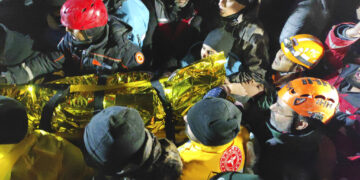 Rescatistas y médicos trasladan a una joven que fue rescatada de entre los escombros de un edificio derruido en Sanliurfa, en el sur de Turquía, el 6 de febrero de 2023, luego de un potente sismo. (IHA via AP)