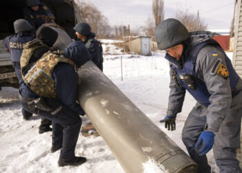 Efectivos de los servicios de emergencia ucranianos cargan los restos de un misil S-300 lanzado por las fuerzas rusas en un camión, en Járkiv, Ucrania, el 17 de febrero de 2023. (AP Foto/Vadim Ghirda)