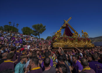 Penitentes de la hermandad de "Padre Jesús Nazareno" cargan un dosel con una estatua de Jesucristo con su cruz durante una procesión de Samana Santa en Priego de Córdoba, en el sur de España, el viernes 7 de abril de 2023. (AP Foto/Manu Fernandez)
