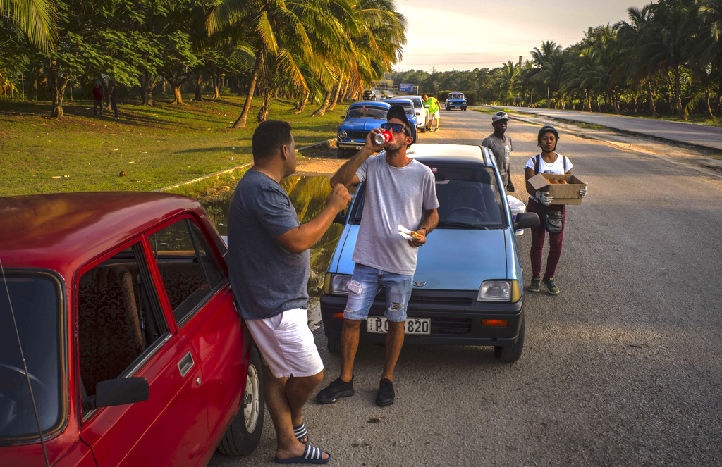 Un conductor se toma un refresco mientras espera la llegada de un camión tanquero de gasolina en La Habana. (Foto: Ramón Espinosa / AP)
