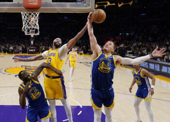 El alero de los Lakers de Los Ángeles Anthony Davis va por el rebote frente a Donte DiVincenzo y Draymond Green de los Warriors de Golden State. (Foto: AP/Ashley Landis)