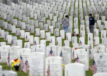 Personas caminan entre las lápidas mientras visitan la Sección 60 del Cementerio Nacional Arlington durante el Día de los Caídos en Guerras, el lunes 29 de mayo de 2023, en Arlington, Virginia. (AP Foto/Alex Brandon)