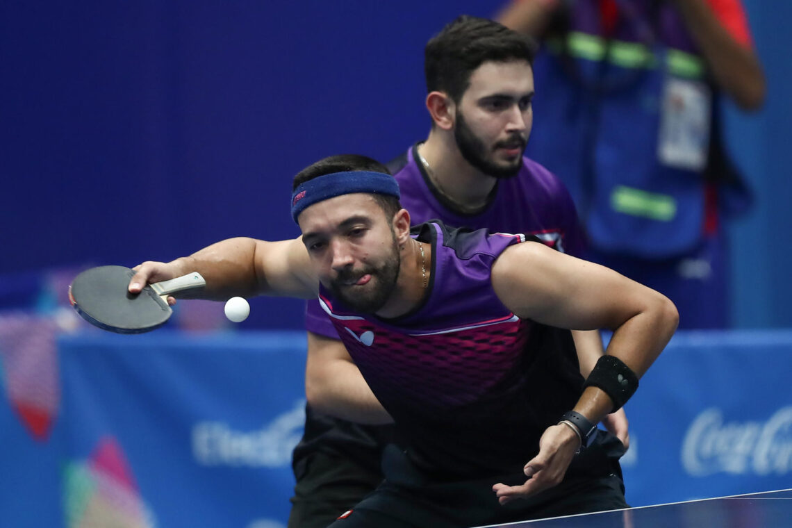 Daniel González (i) y Brian Afanador de Puerto Rico sirven ante Jorge Campos y Livan Martínez de Cuba, en un partido de la final de equipos masculino de tenis de mesa en los Juegos Centroamericanos y del Caribe en San Salvador (El Salvador). EFE/ José Jácome