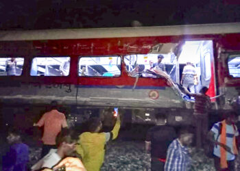 Varias personas revisan el sitio donde un tren se descarriló en el distrito de Balasore. (Foto: Press Trust of India vía AP)
