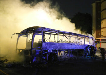 Bomberos arrojan agua a un autobús quemado en Nanterre. (Foto: Lewis Joly / AP)