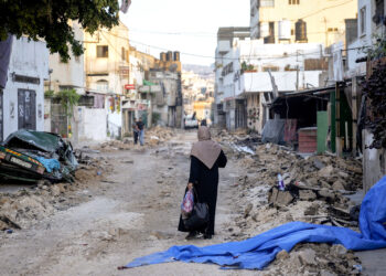 Una mujer palestina camina por una calle dañada en el campo de refugiados de Yenín, en Cisjordania. (Foto: Majdi Mohammed / AP)