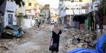 Una mujer palestina camina por una calle dañada en el campo de refugiados de Yenín, en Cisjordania. (Foto: Majdi Mohammed / AP)