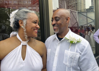 Hazel Seivwright-Carney y su esposo, Rohan Carney, sonríen en el Centro Lincoln de Nueva York, donde la pareja renovó sus votos nupciales durante una boda multitudinaria, el sábado 8 de julio de 2023. (AP Foto/Bobby Caina Calvan)