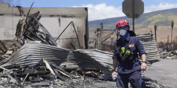 Un trabajador de búsqueda y rescate camina por una calle el sábado 12 de agosto de 2023 en Lahaina, Hawai, tras incendios forestales que causaron graves daños. (AP Foto/Rick Bowmer)