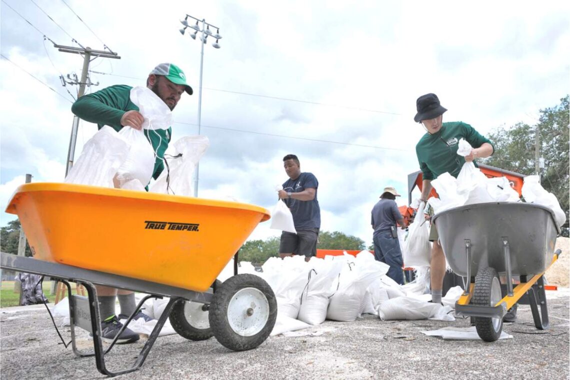 Miembros del departamento de parques y jardines de Tampa, Florida, ayuda a los residentes con costales de arena antes de la llegada de la tormenta Idalia. (Foto: AP/Chris O'Meara)
