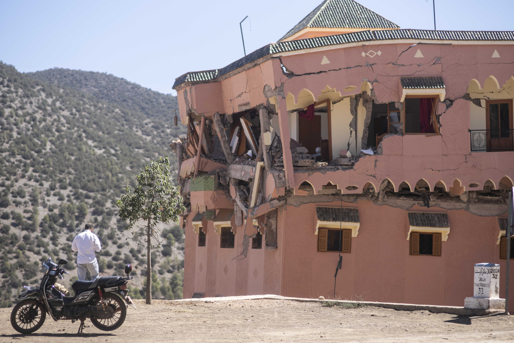 Un hombre de pie junto a un hotel dañado por un sismo en el poblado de Moulay Brahim, cerca del epicentro del sismo, a las afueras de Marrakech, Marruecos, el sábado 9 de septiembre de 2023. (AP Foto/Mosa'ab Elshamy)