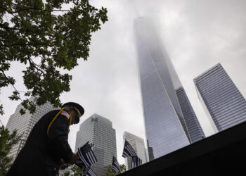 Un uniformado coloca banderas en Nueva York el 11 de septiembre de 2023, para los eventos conmemorativos de los ataques terroristas de septiembre de 2001. (Foto: AP/Yuki Iwamura)