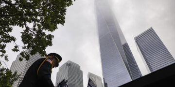 Un uniformado coloca banderas en Nueva York el 11 de septiembre de 2023, para los eventos conmemorativos de los ataques terroristas de septiembre de 2001. (Foto: AP/Yuki Iwamura)