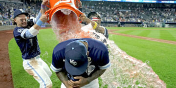 Nelson Velázquez es empapado por Bobby Witt Jr. (izquierda) y MJ Meléndez tras la victoria sobre Houston. (Foto: Charlie Riedel / AP)