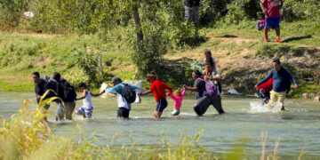 Migrantes cruzan de la mano el río Bravo desde México a Estados Unidos, en Eagle Pass, Texas. (Foto: Eric Gay / AP)