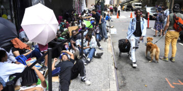 Migrantes forman fila frente al Roosevelt Hotel que se emplea como alojamiento temporero. (Foto: John Minchillo / AP)