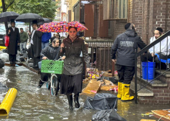 Unos peatones caminan por una acera inundada en Brooklyn. (Foto: Jake Offenhartz / AP)