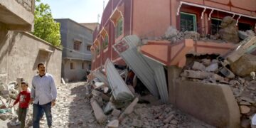 Una persona con un niño camina junto a un edificio dañado tras un terremoto en Marrakech, Marruecos. (Foto: EFE / Jalal Morchidi)