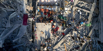 Palestinos inspeccionan los escombros de edificios alcanzados por un ataque aéreo israelí en el campo de refugiados Al Shati, el 12 de octubre de 2023. (Foto: Hatem Moussa / AP)