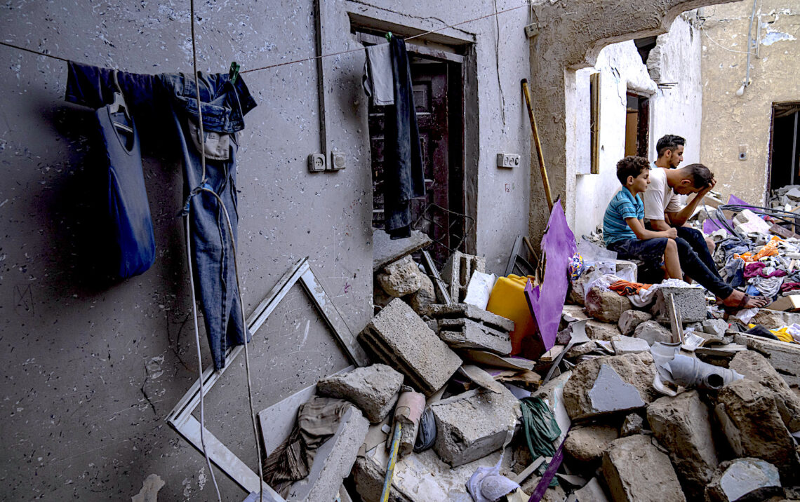Palestinos sentados entre los escombros de una casa después de que fuera alcanzada por un bombardeo israelí en Khan Younis, en el sur de la Franja de Gaza. (Foto: Fatima Shbair / AP)