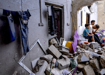 Palestinos sentados entre los escombros de una casa después de que fuera alcanzada por un bombardeo israelí en Khan Younis, en el sur de la Franja de Gaza. (Foto: Fatima Shbair / AP)