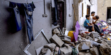 Palestinos sentados entre los escombros de una casa después de que fuera alcanzada por un bombardeo israelí en Khan Younis, en el sur de la Franja de Gaza. (Foto: Fatima Shbair / AP)