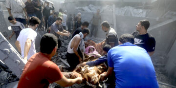 Palestinos trasladan a una mujer herida en el campo de refugiados de Bureij, en la Franja de Gaza. (Foto: Mohammed Dahman / AP)
