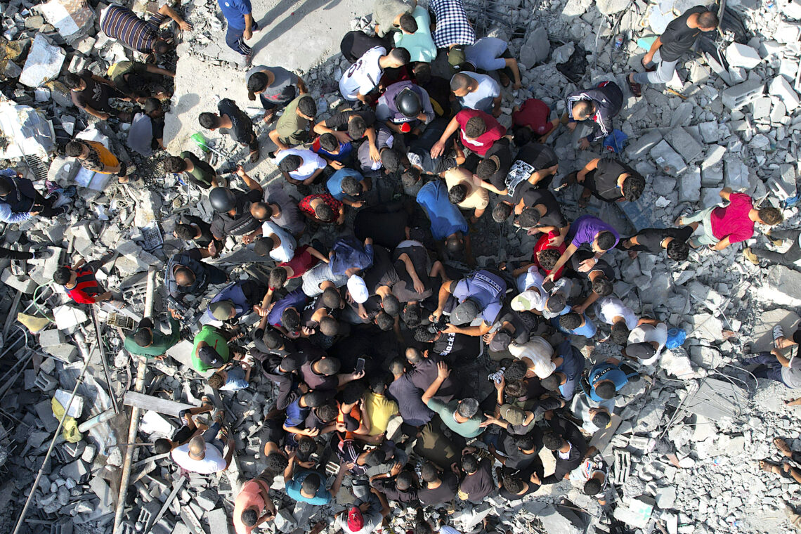 Palestinos buscan sobrevivientes entre los escombros que dejó un bombardeo israelí, en el campamento de refugiados Maghazi, en la Franja de Gaza. (Foto: Hatem Moussa / AP)